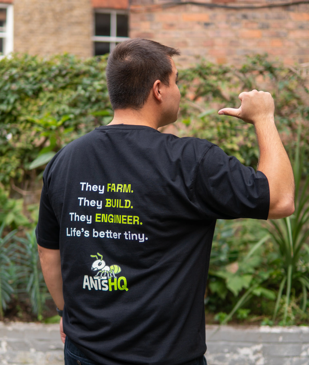 Cesar showing an Ants HQ T-shirt outdoors