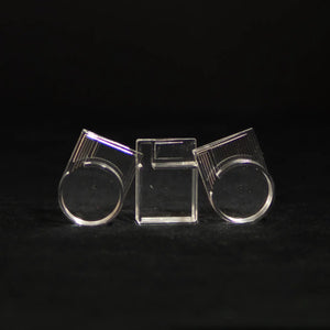 Clear acrylic ant-keeping accessory photographed on a dark background