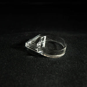 Clear acrylic ant-keeping accessory photographed on a dark background